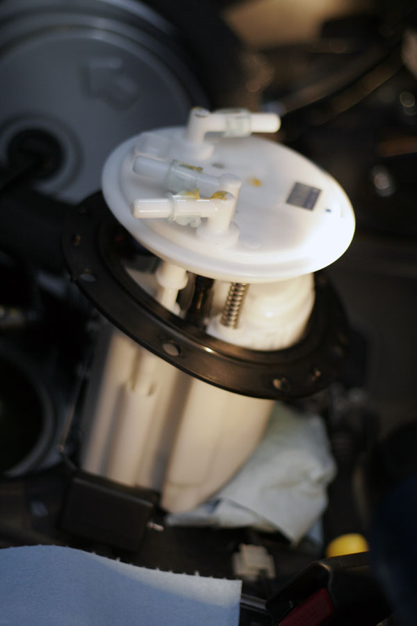 Fuel Pump: Gently remove the metal bracket surrounding the entire assembly to gain access to the housing and place it somewhere safe. Slowly remove the fuel pump assembly by contorting it, be careful not to damage the float or sensor. 