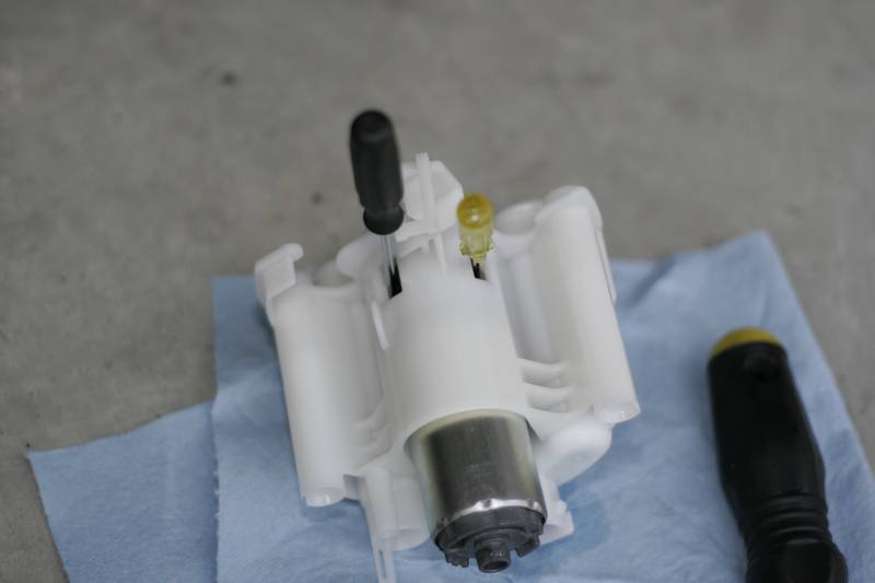 Fuel Pump: Grab two small flatheads and shove them in the openings like shown below. This will allow you to remove the fuel pump. It requires good force so use a pair of pliers if needed.