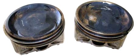 Coolant: These pistons were damaged by an overheated engine. Extensive repairs were required to put the vehicle back on the road.